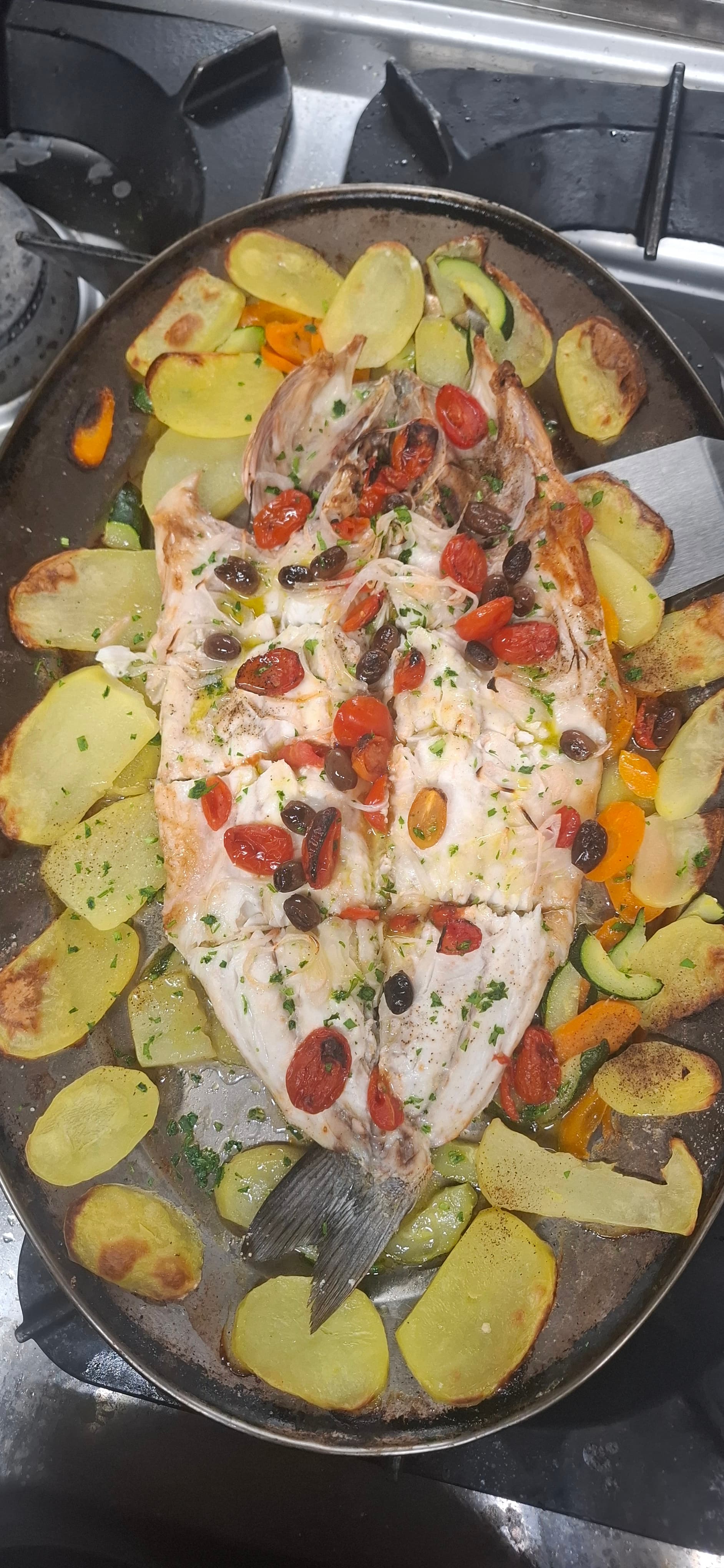 Pesce al forno con patate e olive